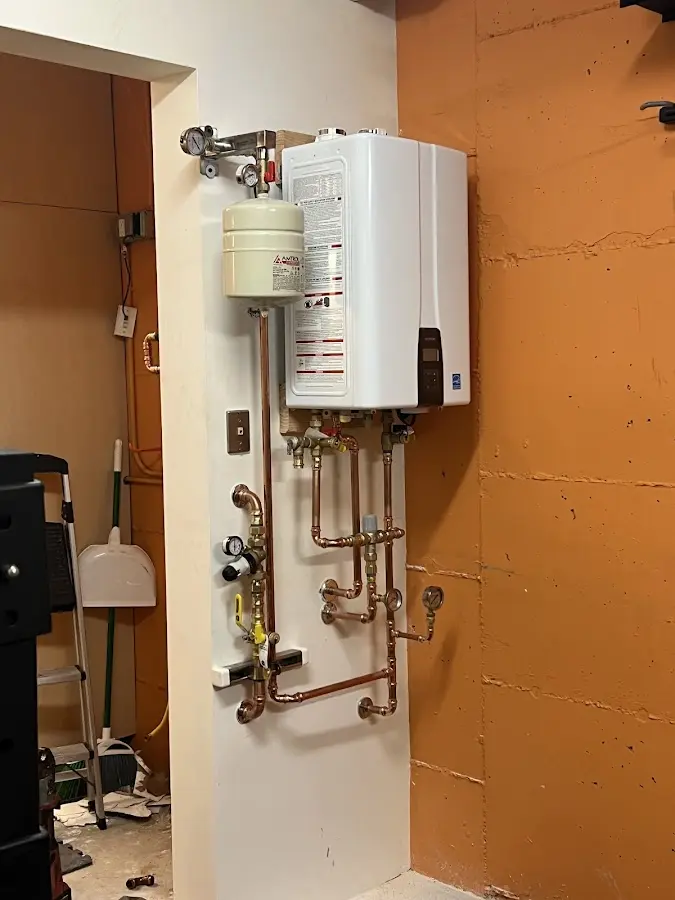 Plumbing technician inspecting water heater connections in Southern Pines